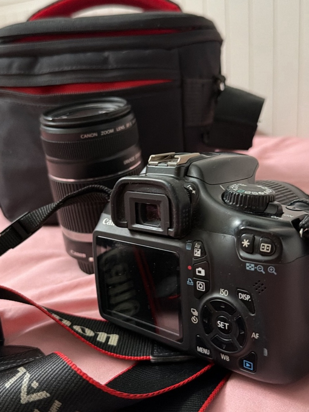 Canon Black DSLR with Black Zoom Lens and Red-Trim Strap